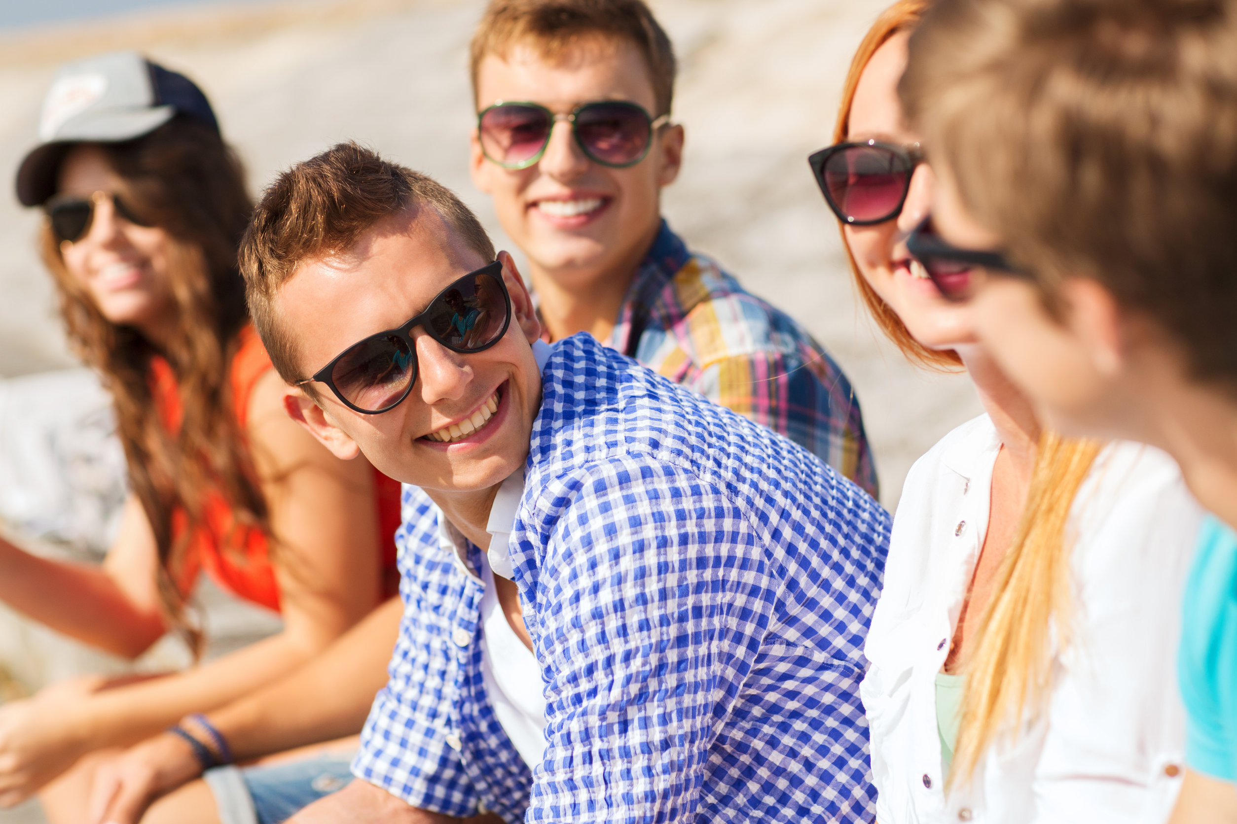 close up of smiling friends sitting on city street